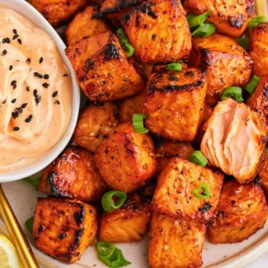 Air fryer salmon bites served with bang bang sauce on a plate