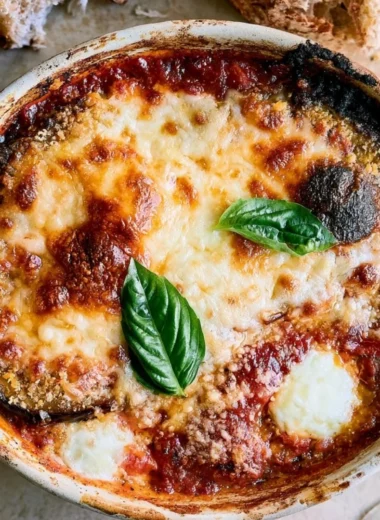 Delicious Eggplant Parmesan served with marinara sauce and melted cheese
