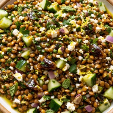 Cozy lentil salad with feta cheese, colorful vegetables, and herbs in a bowl.