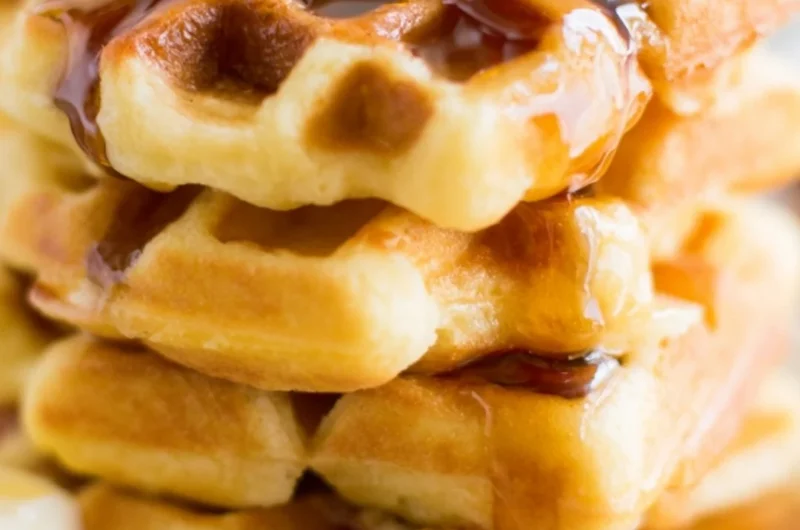 Fluffy and delicious cozy keto waffles topped with fresh berries and butter