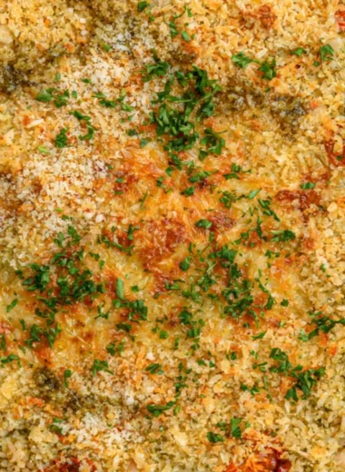 Cozy white bean and pesto bake topped with fresh herbs and cheese.