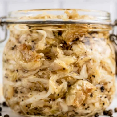 A jar of roasted garlic sauerkraut showcasing its vibrant color and texture.