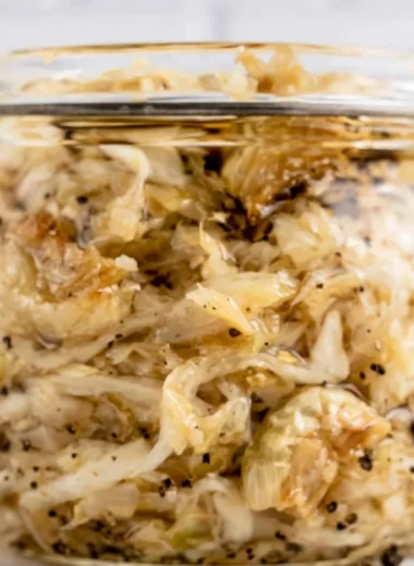 A jar of roasted garlic sauerkraut showcasing its vibrant color and texture.