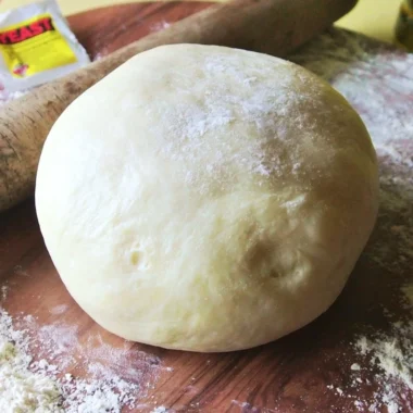 A close-up of a freshly made Italian pizza dough ready for toppings.